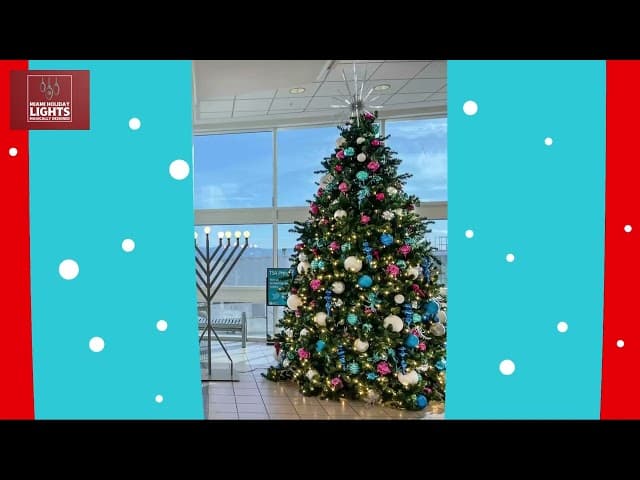 Festive red and green ornaments hang from a high ceiling in a modern transit station.